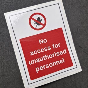 May include: A rectangular sign with a white border, featuring a red rectangle with the text "No access for unauthorised personnel". Above is a red circle with a crossed-out hand symbol.