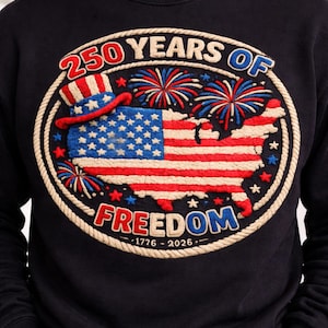 May include: Black sweatshirt with an embroidered design celebrating 250 years of freedom. The design features a map of the United States with the American flag, fireworks, and the text "250 Years of Freedom" and "1776-2026".