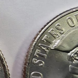 Op de afbeelding: Twee zilverkleurige munten met het profiel van een persoon die een driesteek draagt. De tekst UNITED STATES OF AMERICA staat in reliëf langs de bovenrand en het woord LIBERTY staat aan de rechterkant van de voorzijde van de munt.