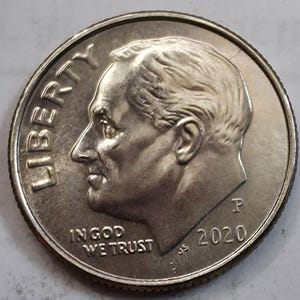May include: A silver-coloured United States ten-cent coin, or dime, featuring the profile of Franklin D. Roosevelt facing left. The coin includes the text LIBERTY, IN GOD WE TRUST, the year 2020, and the mint mark P on the obverse side.