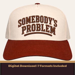 Könnte beinhalten: Baseballcap mit cremefarbener Krone und rostfarbenem Schirm. Der Schriftzug "SOMEBODY'S PROBLEM" ist braun auf die Vorderseite gestickt. Die Kappe hat einen gebogenen Schirm und einen Knopf oben.