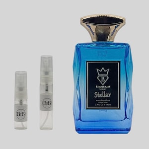 May include: A blue perfume bottle with a gold cap and the word "Stellar" on the label. Two small sample spray bottles are next to the perfume bottle. The perfume bottle is 100ml.