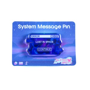 May include: A blue and purple enamel pin with the text "ERROR LOST IN SPACE CONTINUE" on a card that reads "System Message Pin". The pin has a glitch art design and the brand name "Glitch Berry".