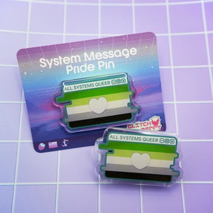 May include: Two clear acrylic Pride pins with the text "ALL SYSTEMS QUEER" and a heart. The pins feature the aroace pride flag with green, white, gray, and black stripes. The pins are on a backing card that says "System Message Pride Pin".