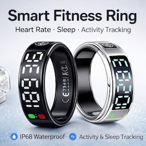 以下が含まれることがあります： 黒とシルバーの2つのスマートフィットネスリング。デジタルディスプレイには数字が表示されます。リングは心拍数、睡眠、活動を追跡します。画像には小さな充電ケースも表示されています。画像には「Smart Fitness Ring」と書かれています。