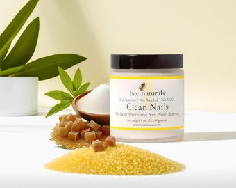May include: A white jar with a black lid labelled "bee naturals" and "Clean Nails" with the text "The Safer Alternative Nail Polish Remover" and "net weight 4 oz (113.40 grams)".