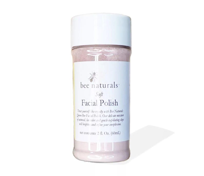 May include: A white jar with a pink label that says "bee naturals" and "Soft Facial Polish". The jar contains a pink facial polish. The label also says "Treat yourself like royalty with Bee Naturals Queen Bee Facial Polish. Our delicate mixture of oatmeal, lavender and 1 gentle exfoliating clay will brighten and refine your complexion. Net contents 2 fl. Oz. (60ml)"