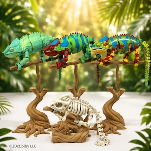 May include: Three articulated chameleon figures in light green, blue-green with red, and multi-colored patterns, plus one white skeletal chameleon figure. Each figure is perched on a brown branch stand. The text 3DxColby LLC is visible.