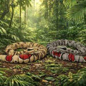 May include: Two coiled snake sculptures with tan, brown, red, and grey patterns rest on a forest floor. The snakes have yellow eyes and are surrounded by lush green foliage. The image is set in a jungle environment.