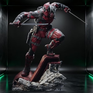 May include: A detailed statue of Deadpool in a dynamic pose, clad in a red and black suit, holding two katanas. The figure is posed on a rocky base with a dark background, showcasing the character's iconic mask and costume details.