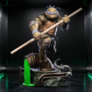 Può includere: Statuetta dettagliata di Leonardo delle Tartarughe Ninja. La figura è in posa su un tubo fognario con una melma verde che fuoriesce. Leonardo tiene in mano il suo bastone bo, indossa una maschera blu e un'armatura.
