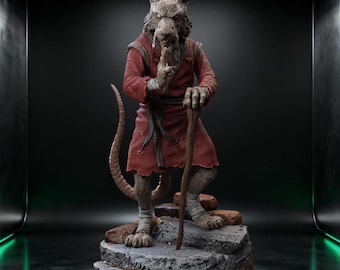 May include: A detailed statue of a rat-like humanoid figure in a red robe, holding a wooden staff and gesturing with a finger to the lips. The figure stands on a rocky base, with a long tail extending behind it.