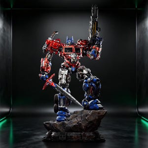 Peut inclure: Figurine détaillée d'Optimus Prime, un robot rouge, bleu et argenté, tenant une grosse arme et une épée. La figurine est posée sur une base rocheuse avec une finition métallique détaillée, montrant des détails mécaniques complexes.