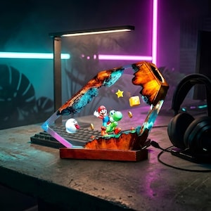 K&ouml;nnte beinhalten: Dekorative Harzlampe mit einer Super Mario Bros. Szene mit Mario und Yoshi. Die Lampe hat einen Holzsockel und ein geometrisches Design. Enth&auml;lt einen Boo-Geist, M&uuml;nzen und einen Stern.