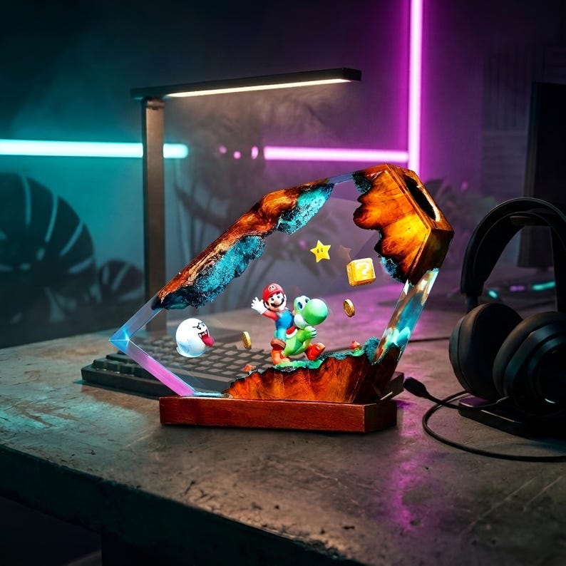 K&ouml;nnte beinhalten: Dekorative Harzlampe mit einer Super Mario Bros. Szene mit Mario und Yoshi. Die Lampe hat einen Holzsockel und ein geometrisches Design. Enth&auml;lt einen Boo-Geist, M&uuml;nzen und einen Stern.