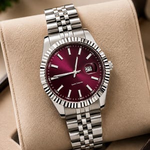 May include: A silver wristwatch with a burgundy dial and a date display at the 3 o'clock position. The watch has a fluted bezel and a stainless steel bracelet. The words "Quartz Calendar" are printed on the dial.