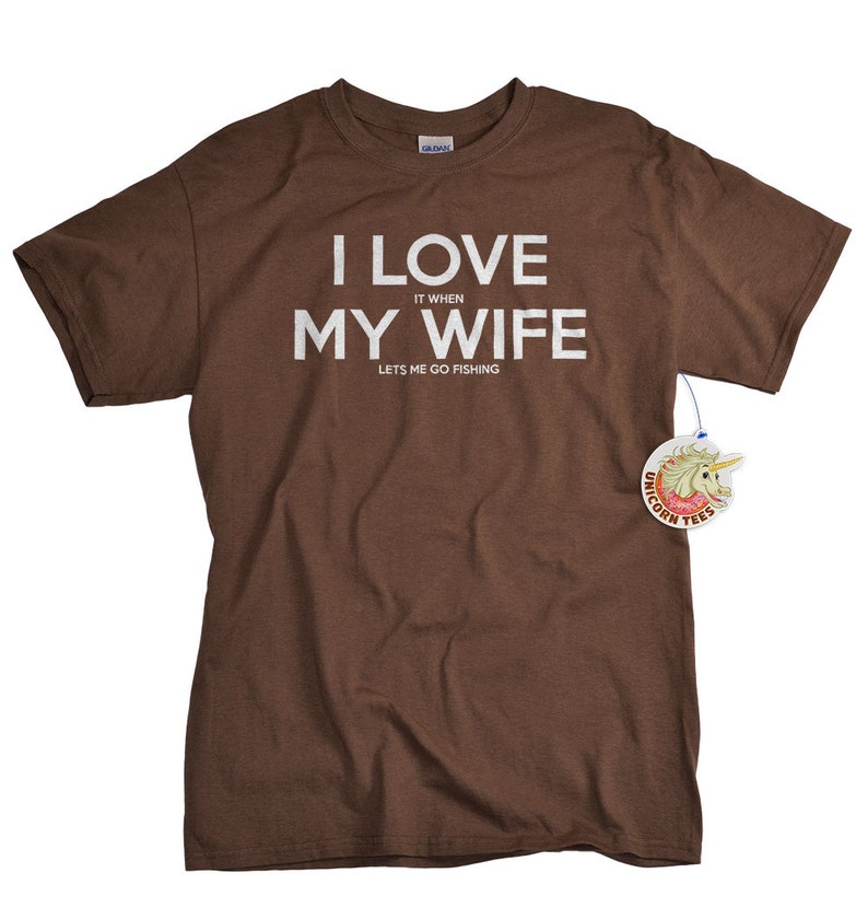May include: Brown t-shirt with white text that reads "I love it when my wife lets me go fishing".