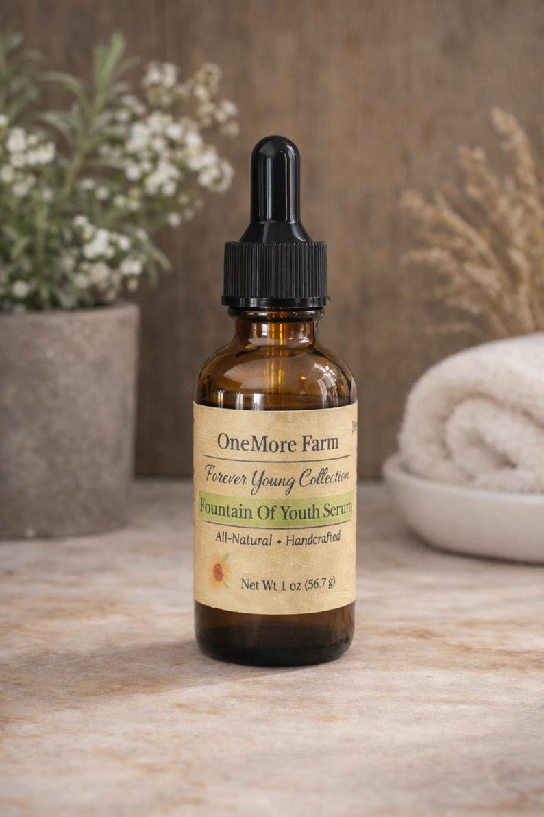 Puede incluir: Una botella de vidrio marr&oacute;n con un cuentagotas negro, etiquetada como "OneMore Farm Forever Young Collection Fountain Of Youth Serum". La etiqueta tambi&eacute;n indica "All-Natural Handcrafted" y "Net Wt 1 oz (56,7 g)."