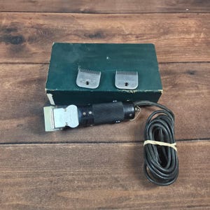 May include: A white ceramic mug with a black handle and the text "But First, Coffee" in a bold, black font. The mug is set against a neutral background, highlighting its simple design.