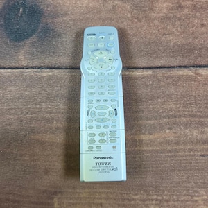 Könnte beinhalten: Eine silberne Panasonic Tower Universalfernbedienung mit Ziffernblock, Wiedergabesteuerung und verschiedenen Funktionstasten. Im unteren Bereich sind der Markenname Panasonic, der Modellname TOWER und der Text DVD/VCR/TV/CABLE/DSS zu sehen.