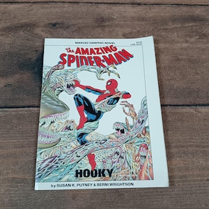 May include: A Marvel graphic novel titled "The Amazing Spider-Man" with a colorful illustration of Spider-Man in action. The cover features the word "HOOKY" and the names Susan K. Putney & Berni Wrightson.