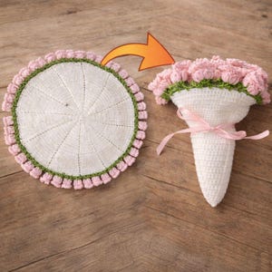 May include: A crocheted bouquet of pink flowers with green detailing, held in a white cone shape, tied with a pink ribbon. Beside it is a matching crocheted round coaster with pink and green trim.
