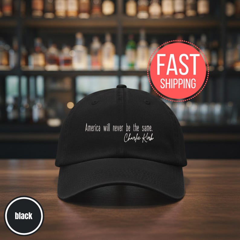 以下が含まれることがあります： 白文字で「America will never be the same. Charlie Kirk」と書かれた黒い野球帽。帽子はカーブしたつばと、クラシックな6パネルのデザインです。「FAST SHIPPING」と書かれた赤い円が背景にあります。