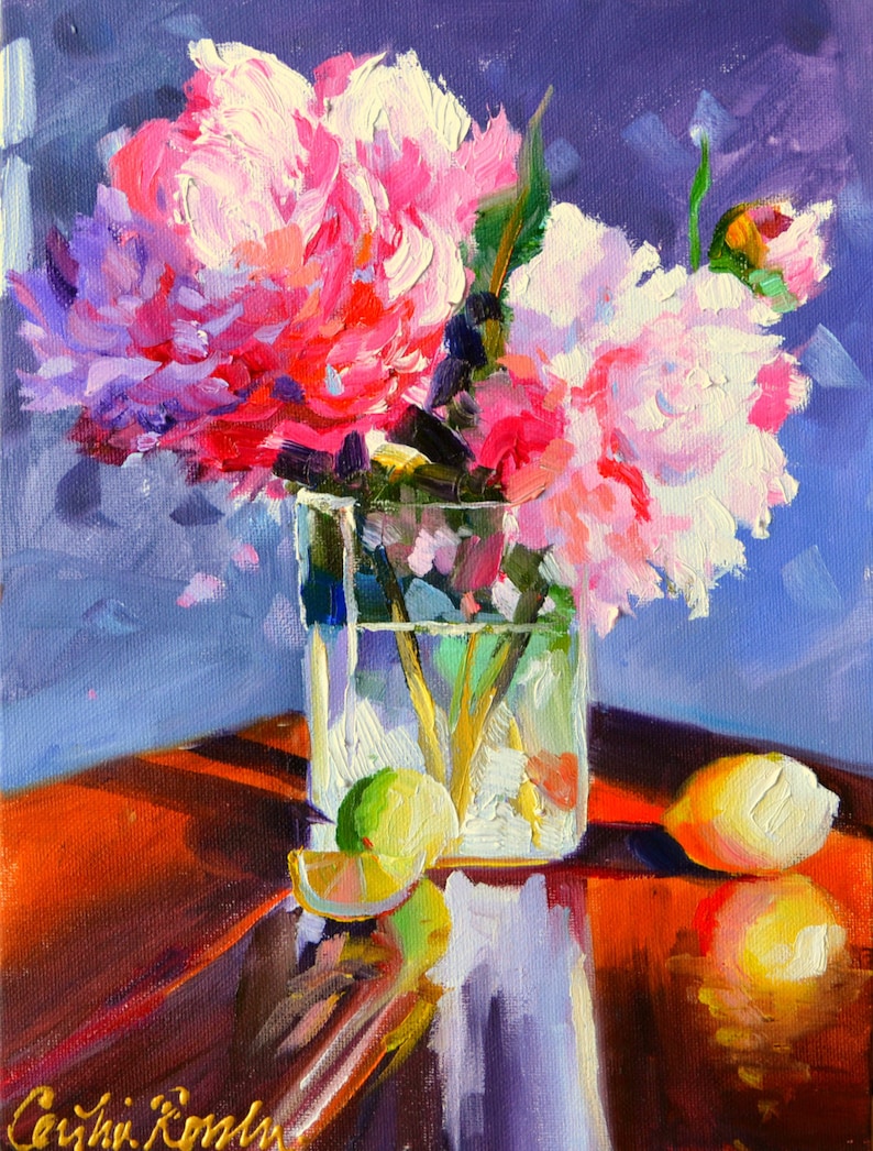 May include: Oil painting of pink and white peonies in a clear glass vase. A lemon and lime sit on a reflective, reddish-brown surface. The background is a deep blue.
