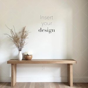 May include: A wooden bench with a minimalist design, featuring a light brown finish. A white vase with dried plants and a wooden bowl with white flowers are placed on the bench. The text "Insert your design" is visible on the wall.