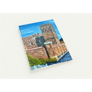 May include: An angled view of a watercolor painting of a brick building with a tall tower. The painting features a blue sky with clouds, and green and red plants at the base of the building.