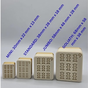 Puede incluir: Cuatro moldes rectangulares de silicona beige con bordes dorados, ordenados por tama&ntilde;o. Las etiquetas de texto indican las dimensiones: MINI: 30mm x 22mm x 13mm, STANDARD: 38mm x 28mm x 18mm, JUMBO: 58mm x 48mm x 28mm y GOLIATH: 68mm x 58mm x 38mm.