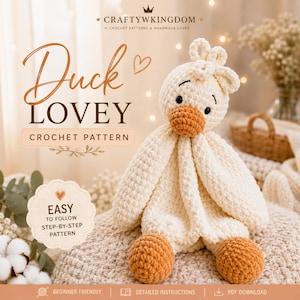 May include: A crochet pattern for a duck lovey featuring text that reads CRAFTYWKINGDOM, Duck LOVEY, CROCHET PATTERN, and EASY TO FOLLOW STEP-BY-STEP PATTERN. The image displays a cream-coloured crocheted duck with an orange beak and feet.