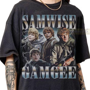 Op de afbeelding: Een zwart t-shirt met korte mouwen en een grafische print van het personage Samwise Gamgee in drie verschillende houdingen. De tekst SAMWISE staat in een metallic zilveren lettertype boven de afbeeldingen en GAMGEE staat eronder, met bliksem.