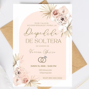 Op de afbeelding: Een blush roze bruidsdouche-uitnodiging met bloemaccenten en gouden tekst. De uitnodiging bevat de tekst "Despedida de Soltera" en details voor het evenement, inclusief datum, tijd en RSVP-informatie.