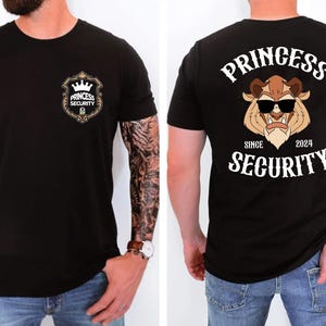 Könnte beinhalten: Schwarzes T-Shirt mit "Princess Security" auf Vorder- und Rückseite. Die Vorderseite zeigt ein Schilddesign mit einer Krone. Die Rückseite zeigt ein Cartoon-Biest mit Sonnenbrille und dem Text "Princess Security Since 2024".