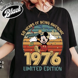 Puede incluir: Camiseta negra con un diseño vintage de Mickey Mouse celebrando 50 años. El diseño incluye el texto "50 Years of Being Awesome", el año "1976" y "Limited Edition".