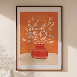 Könnte beinhalten: Gerahmter Kunstdruck mit einer roten Vase mit weißen Blumen vor orangefarbenem Hintergrund. Die Vase hat ein dekoratives Muster am Rand. Das Kunstwerk ist in einem Holzrahmen präsentiert, der eine warme Ästhetik erzeugt. Größe: ca. 40 cm x 50 cm.