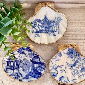 May include: A set of three ceramic nesting bowls in shades of blue, green, and white. The bowls feature a speckled glaze and a simple, modern design. The largest bowl measures approximately 6 inches in diameter.