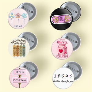May include: A collection of round pinback buttons with various designs and text. Designs include flowers, a bandage with "Jesus Heals," inspirational quotes, and the word "Jesus" with different phrases. Each button has a metal back.