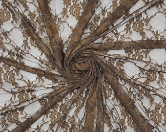 May include: A dark brown lace fabric featuring a delicate floral pattern with intricate scalloped edges. The sheer material is gathered in a central spiral, creating radiating folds that highlight the detailed embroidery and openwork design.