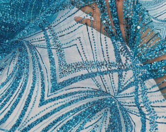 May include: A sheer turquoise fabric featuring an intricate pattern of geometric lines and floral-inspired shapes. The design is heavily embellished with small, shimmering turquoise sequins that follow the linear and curved motifs throughout.