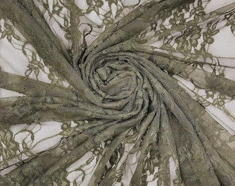 May include: A sheer olive green lace fabric featuring a detailed floral pattern. The material is gathered in a central spiral, showcasing the intricate mesh texture and the delicate, repeating botanical motifs woven throughout the textile.