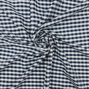Könnte beinhalten: Nahaufnahme eines marineblauen und weißen Vichy-Stoffs. Der Stoff ist in weichen Falten angeordnet, mit einer Spirale in der Mitte. Das Karomuster ist gleichmäßig angeordnet und schafft ein klassisches und vielseitiges Textil.