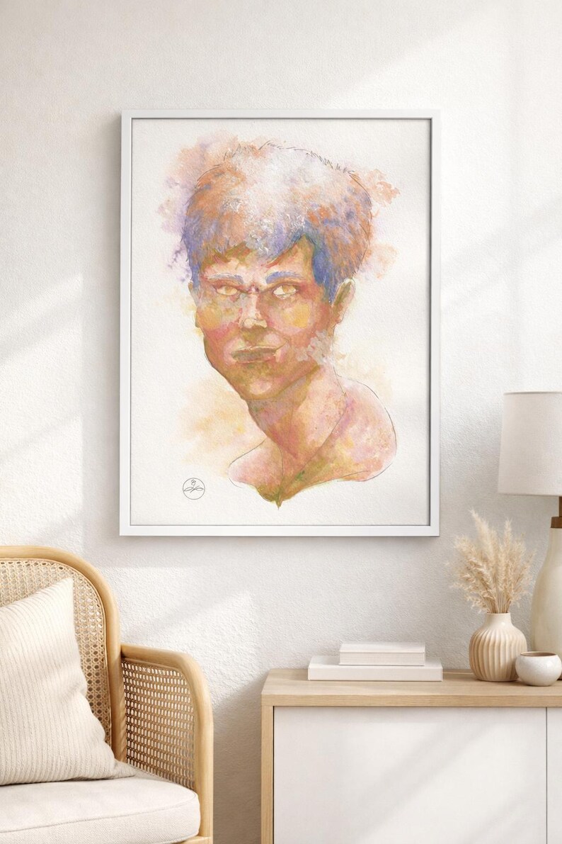 May include: Watercolor portrait of a person in a white frame. The artwork features a face with a stern expression, rendered in shades of yellow, pink, and blue. The painting is displayed on a white wall above a wooden cabinet.