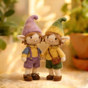 May include: Two handmade felt dolls, each with a whimsical elf-like appearance. One doll wears a purple hat, yellow shirt, blue overalls, and brown shoes. The other doll has a green and yellow hat, yellow shirt, green shorts, and a brown satchel.