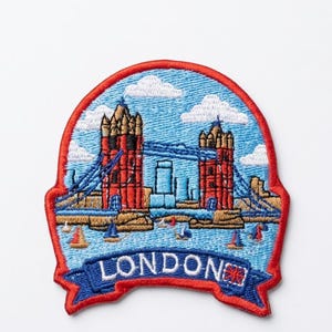 Pode incluir: Patch bordado com a Tower Bridge em Londres, com um fundo de céu azul e nuvens brancas. O patch tem uma borda vermelha e uma faixa azul com a palavra "LONDON" e uma bandeira da Union Jack.
