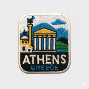 Puede incluir: Parche bordado con una colorida ilustración de Atenas, Grecia. El diseño incluye un templo, montañas y el texto "ATHENS GREECE" en negro y azul. El parche tiene un borde blanco.