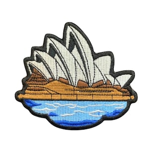 Op de afbeelding: Geborduurde patch met het Sydney Opera House. De patch toont het gebouw met witte zeilen, bruin land en blauw water. De patch heeft een zwarte rand.