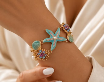 Bracciale da spiaggia con stelle marine e conchiglie, gioiello estivo per lei, bracciale rigido in smalto dorato, accessorio per le vacanze, regalo per gli amanti del mare.