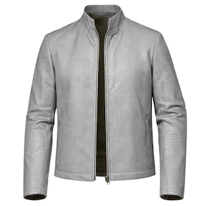 Może przedstawiać: Jasnoszara skórzana kurtka z wysokim kołnierzem i pełnym zamkiem błyskawicznym. Kurtka ma teksturowany wzór przypominający skórę gada i długie rękawy. Wewnętrzna podszewka jest w ciemniejszym odcieniu szarości.